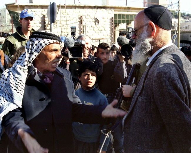 (Ünlü sivil Yahudi işgalcilerden Moshe Levinger ve bir Filistinli, El-Halil, 1997. Fotoğraf: Reuters)